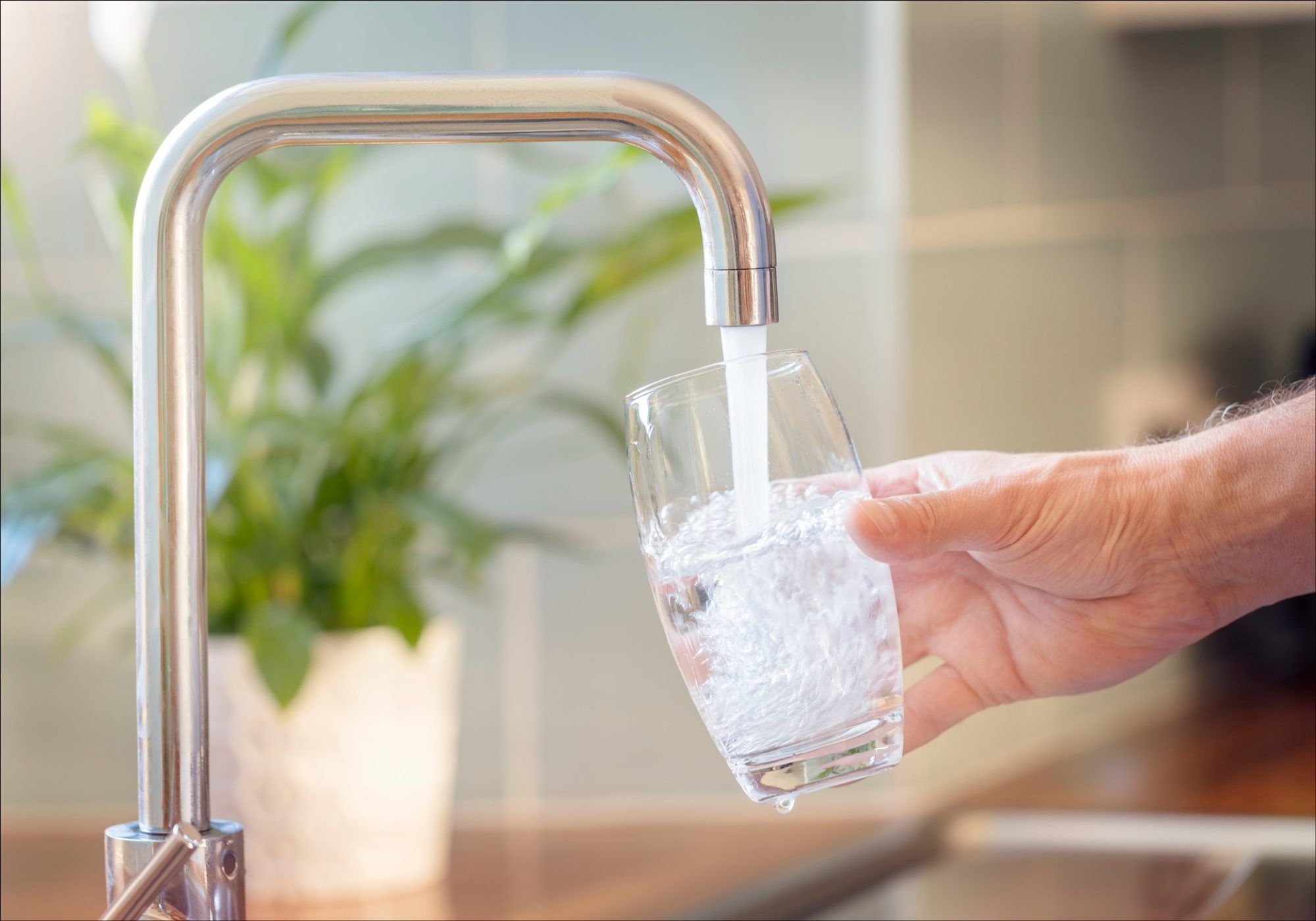 Image of someone pouring a glass of water from a tap